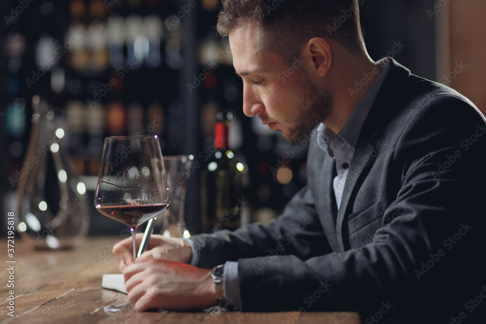 Sommeliers male hold glass red wine tasting degustation card Sommeliers male hold glass red wine tasting degustation card