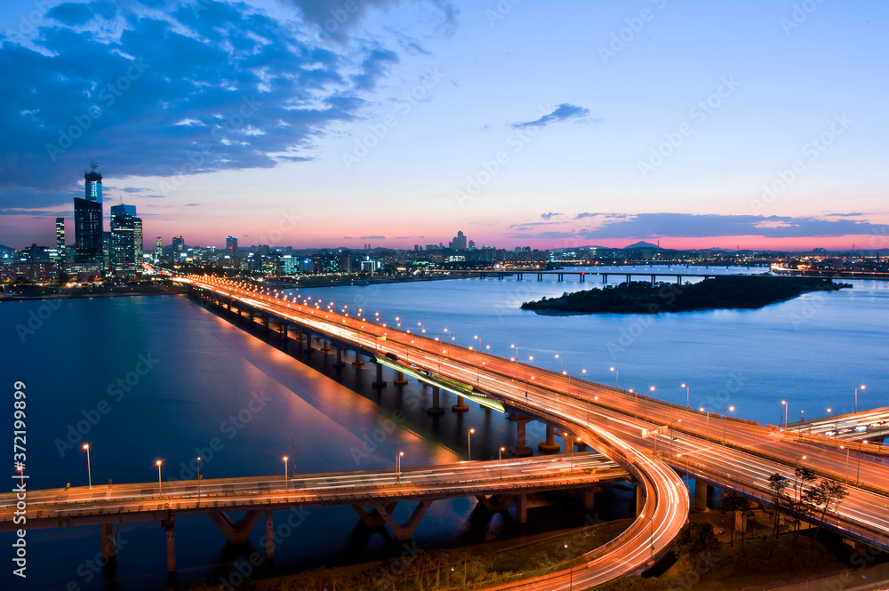 Wonderful sunset night view of the grand bridge and cityscape.