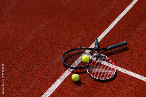 A tennis racket and new tennis ball on a freshly painted tennis court © Angelov