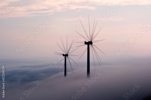 Wind generator trails at dawn,in the misty mountain,C