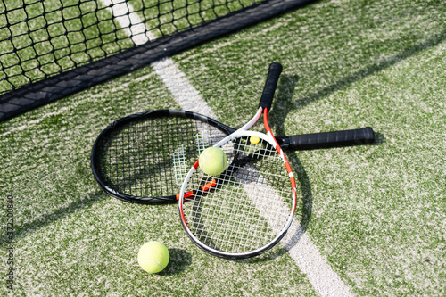 A tennis racket and new tennis ball on a freshly painted tennis court