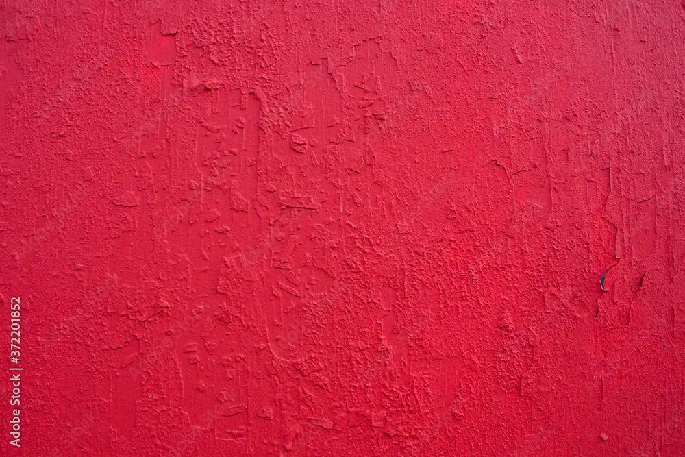 Texture of rough concrete wall covered and painted red decorative stucco. Background of blood-red colored plaster with cracks on concrete wall. Dark-red stucco decorative wall coating. Texture of rough concrete wall covered and painted red decorative stucco. Background of blood-red colored plaster with cracks on concrete wall. Dark-red stucco decorative wall coating.