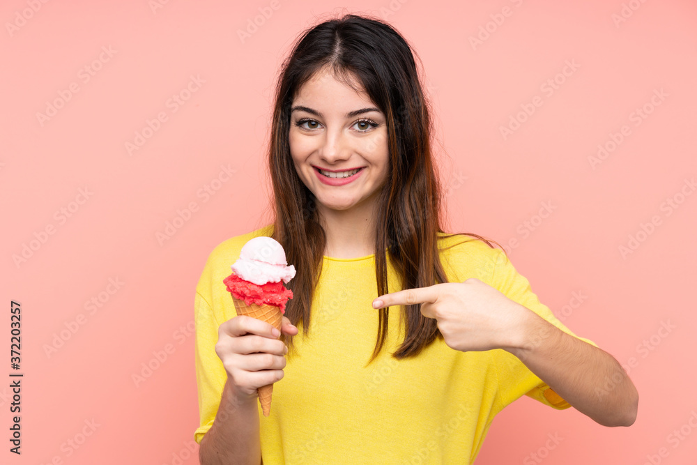 Young brunette woman holding a cornet ice cream over isolated pink background with surprise facial expression Young brunette woman holding a cornet ice cream over isolated pink background with surprise facial expression