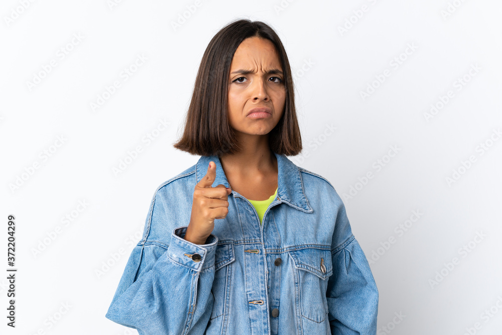 Young latin woman isolated on white background frustrated and pointing to the front Young latin woman isolated on white background frustrated and pointing to the front