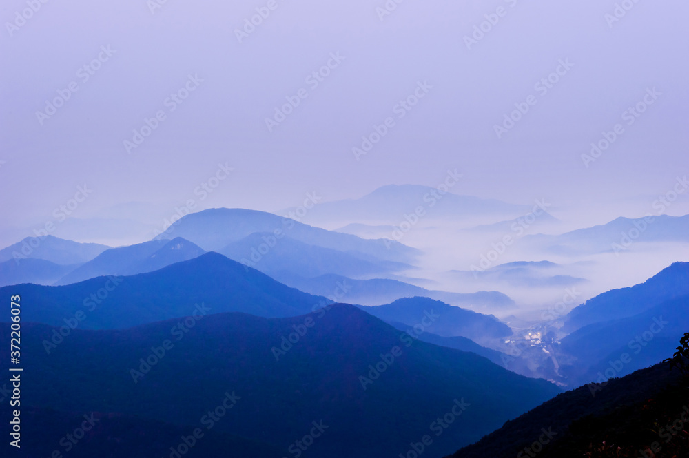 The dreaming blue mountainscape  with misty and foggy at dawn.