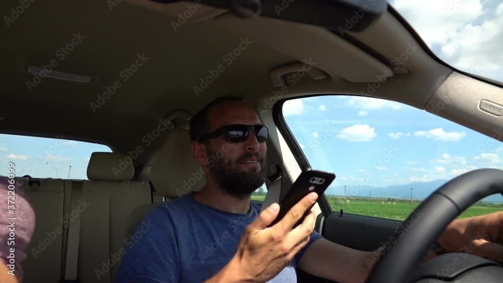 Happy man talking on cellphone, driving the car, slow motion Happy man talking on cellphone, driving the car, slow motion