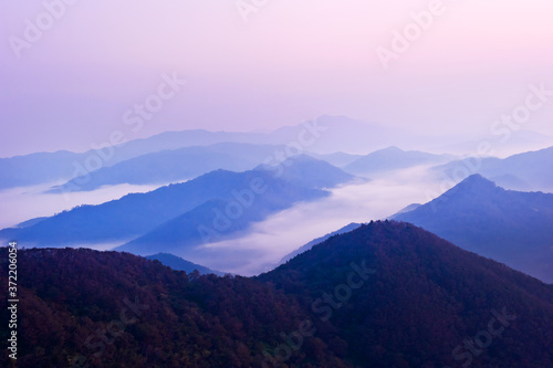The dreaming blue mountainscape with misty and foggy at dawn.