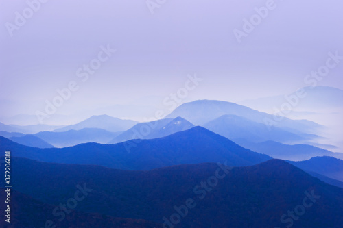 The dreaming blue mountainscape with misty and foggy at dawn.