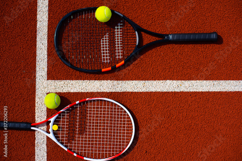 A tennis racket and new tennis ball on a freshly painted tennis court © Angelov