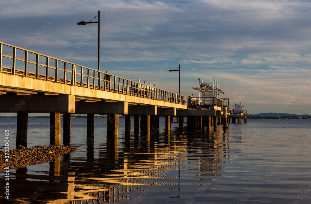 Obraz premium Jetty in golden light with reflections in water