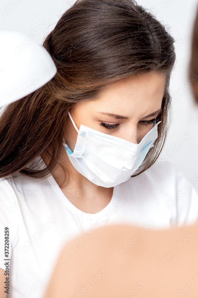 Manicurist wearing protective mask painting female nails with nail polish in manicure salon. Manicurist wearing protective mask painting female nails with nail polish in manicure salon.