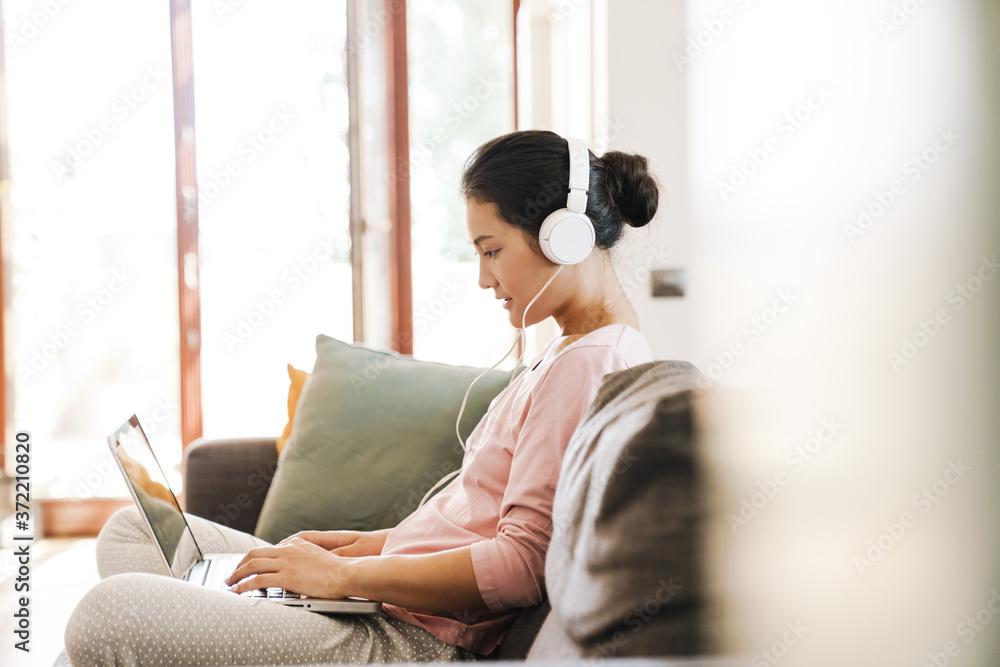 Fototapeta premium Young woman relaxing on a sofa in the living room