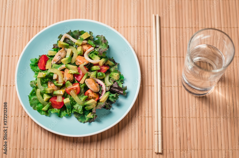 Top view - Salad with seafood on color plate Top view - Salad with seafood on color plate