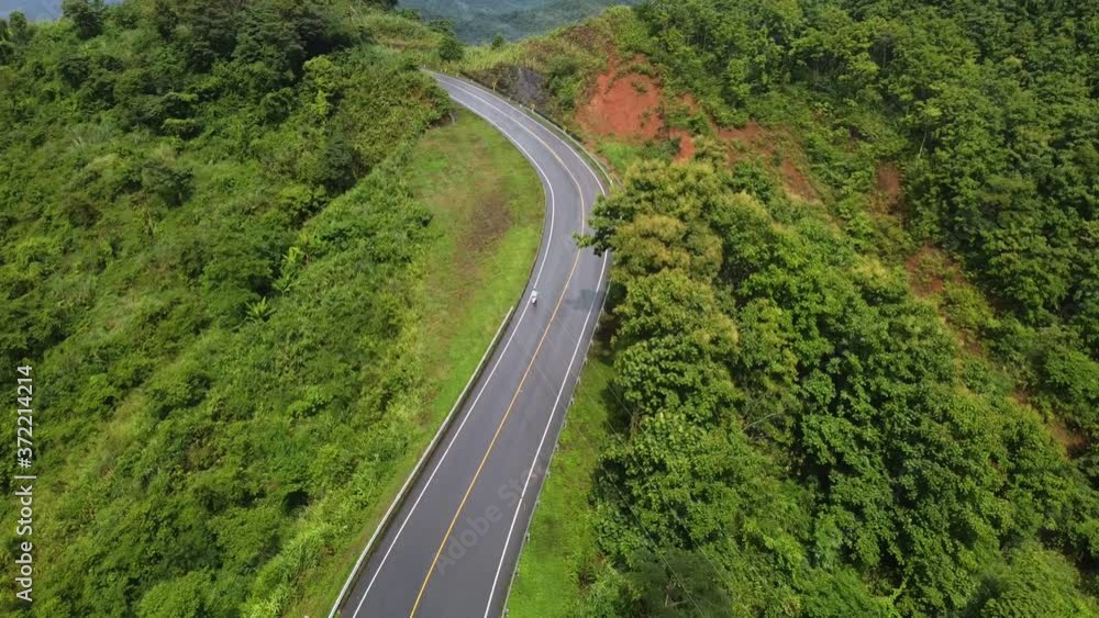 Nan, Thailand. Aerial view of Beautiful sky road over top of mountains with green jungle. Road trip on curve road in mountain. Nan, Thailand. Aerial view of Beautiful sky road over top of mountains with green jungle. Road trip on curve road in mountain.