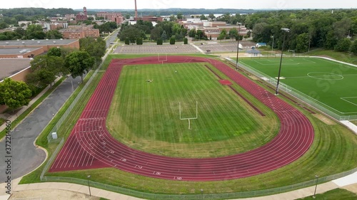 Rotating aerial view of well maintained and mowed soccer field with running track at University of Wisconsin–Stout  in Menomonie, Wisconsin. photo