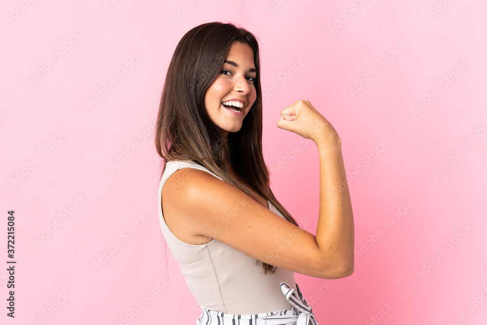 Young brazilian woman isolated on pink background doing strong gesture Young brazilian woman isolated on pink background doing strong gesture