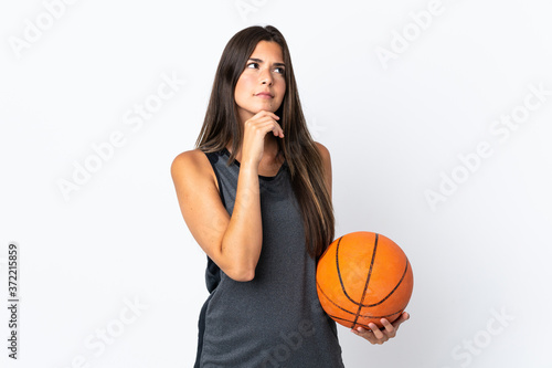 Young brazilian woman playing basketball isolated on white background and looking up © luismolinero
