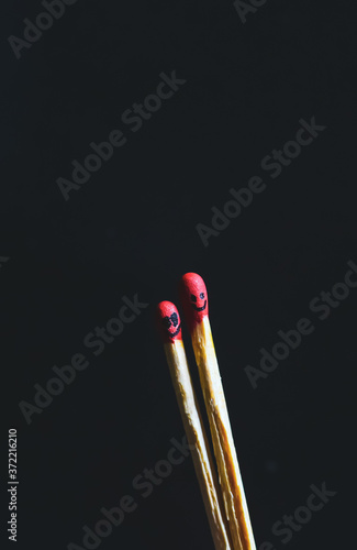 Couple of matches burning together with heat flame isolated on a black background.