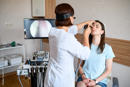 Photography Female otolaryngologist and patient in office, exa