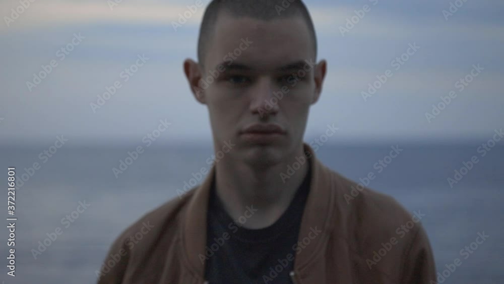 Serious Looking Man Turning Head On Both Sides Isolated On Opaque Blue Sea Background - Closeup Shot Serious Looking Man Turning Head On Both Sides Isolated On Opaque Blue Sea Background - Closeup Shot