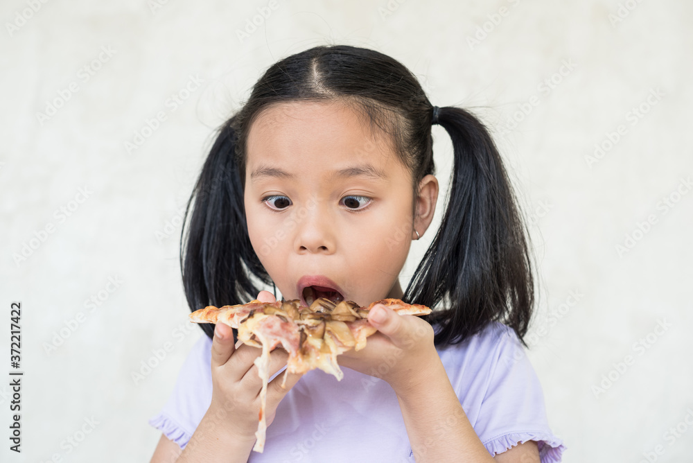 cute little girl holds piece of pizza, hungry student opens mouth wide while sees delicious slice of pizza, wants to eat, positive woman with junk food, people and eating, people and snack concept. cute little girl holds piece of pizza, hungry student opens mouth wide while sees delicious slice of pizza, wants to eat, positive woman with junk food, people and eating, people and snack concept.