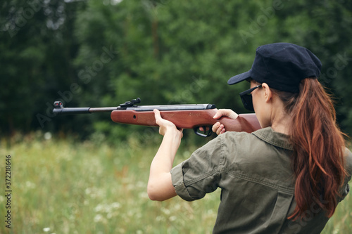 Woman Holds aiming hunting green overalls 