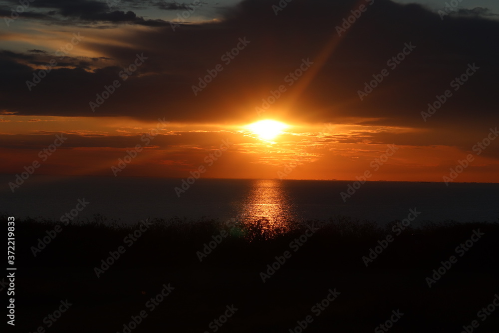 Hunstanton beach sun set over the sea ,glowing deep orange ball of fire Hunstanton beach sun set over the sea ,glowing deep orange ball of fire