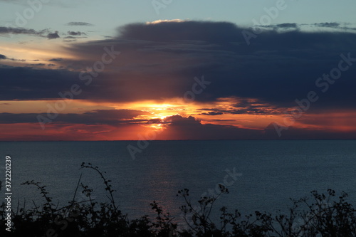 Hunstanton beach sun set over the sea ,glowing deep orange ball of fire 