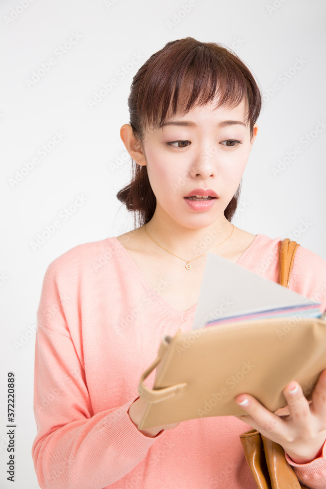 スケジュール帳を見る女性 スケジュール帳を見る女性