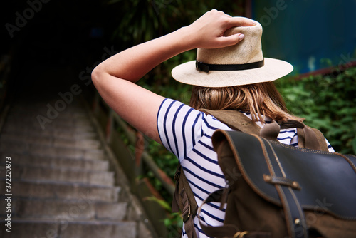Rear view of woman in a hat climbing stairs