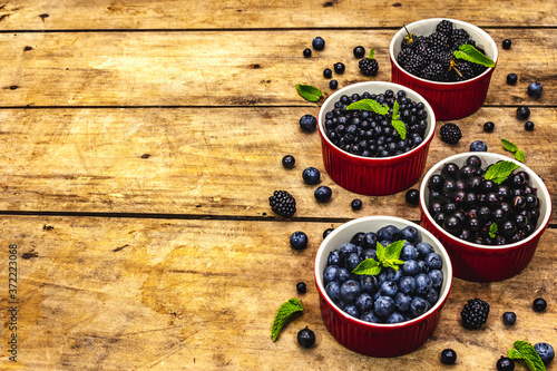 Fototapeta Naklejka Na Ścianę i Meble -  Assorted berries in blue and black colors: bilberry, blueberry, currant and blackberry