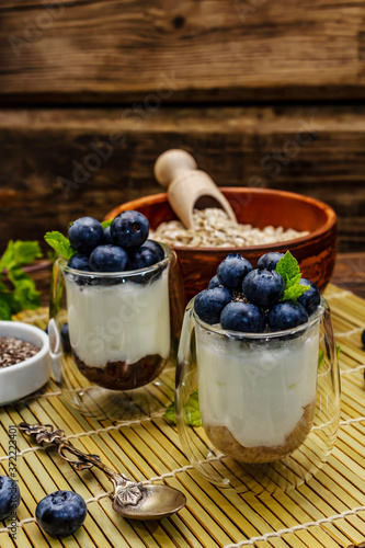 Healthy and useful breakfast concept. Yogurt with blueberries, oat-flakes and chia seeds