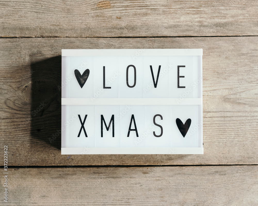 Love Christmas text in led panel with wooden background Love Christmas text in led panel with wooden background