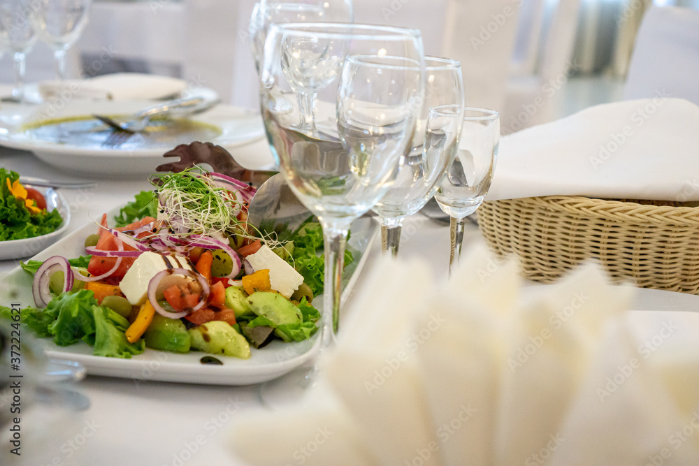 Beautiful table setting in light colors with dishes and assorted food on a table with a white tablecloth for a party, wedding or other special event. Restaurant business and service industry concept. Beautiful table setting in light colors with dishes and assorted food on a table with a white tablecloth for a party, wedding or other special event. Restaurant business and service industry concept.