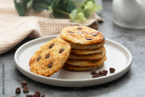 Stack of chocolate chip cookies. Dark background. Sweet delicious snack.