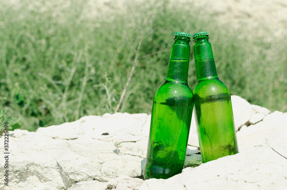 Two bottle of light beer on the rocks.Empty space.Relaxing and cold drinks