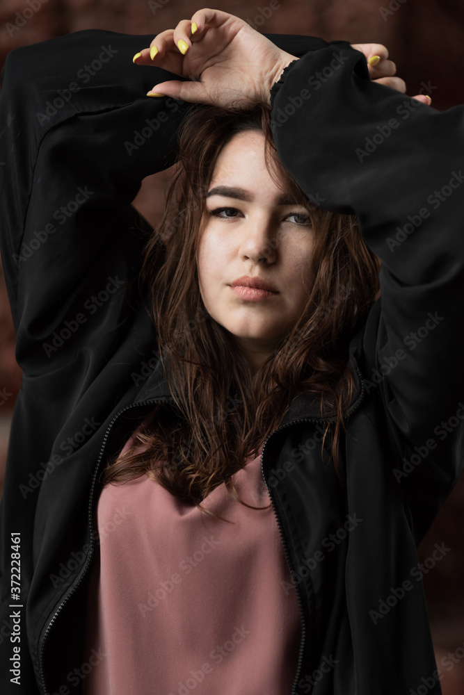 Young woman with hand on head looks at the camera Young woman with hand on head looks at the camera