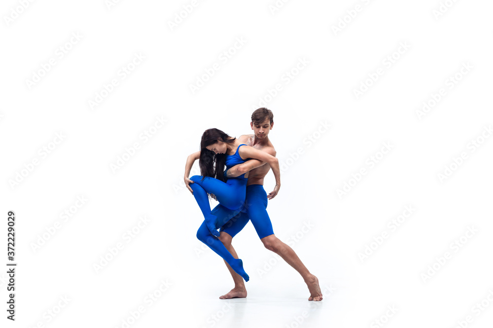 Like child. Couple of modern dancers, art contemp dance, blue and white combination of emotions. Flexibility and grace in motion and action on white studio background. Fashion and beauty, artwork