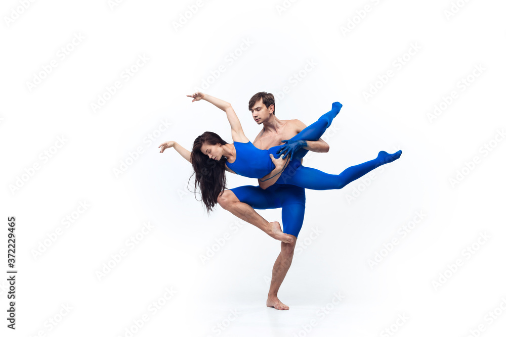 Target. Couple of modern dancers, art contemp dance, blue and white combination of emotions. Flexibility and grace in motion and action on white studio background. Fashion and beauty, artwork concept.