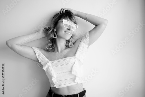 Photo of the model in black and white, white top, glasses, more earrings, bracelets and accessories.