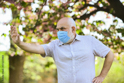 Stop pandemic. Do not touch your face. Support elderly during coronavirus lockdown and social distancing. Senior man wearing face mask. Safety measures. Coronavirus pandemic. Pandemic concept