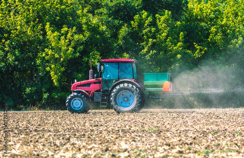 The tractor applies fertilizer to the soil. Agricultural work.