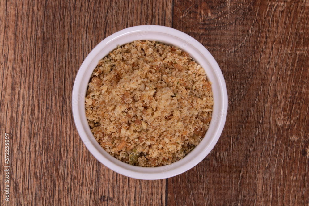 crumbs in bowl on wooden background crumbs in bowl on wooden background