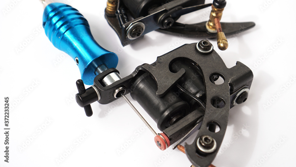 Two tattoo machines on a white background - tattoo industry Two tattoo machines on a white background - tattoo industry