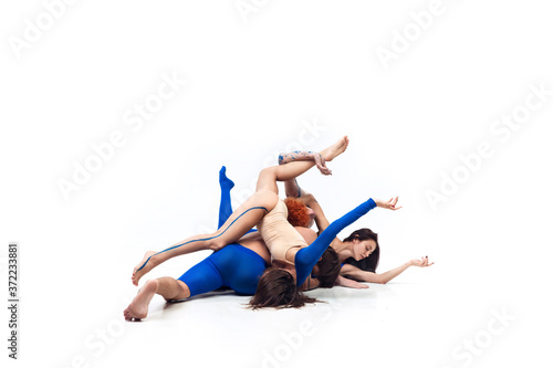 Spider. Group of modern dancers, art contemp dance, blue and white combination of emotions. Flexibility and grace in motion and action on white studio background. Fashion and beauty, artwork concept.