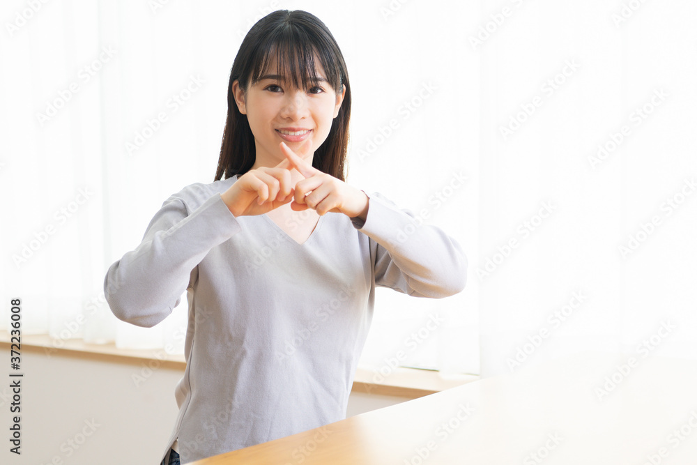NGのサインを作る若い女性