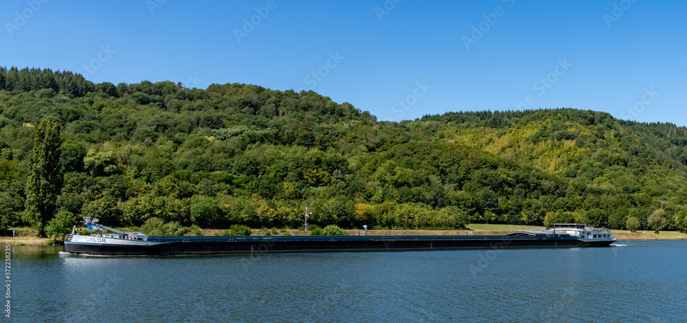 large river barge transporting goods on the Moselle River near Enkirch