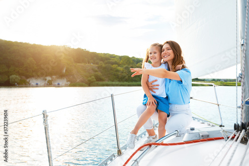 Happy Mother And Daughter On Yacht Deck Enjoying Boat Ride
