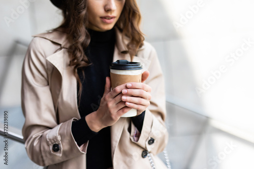 Shopping day. Coffee break. Attractive young woman with paper bags walking on city street.