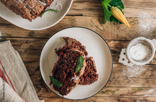 Vegan crunchy chocolate zucchini cake on rustic wooden. Healthy gluten free food.